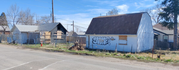Picture of the burned house and the detached garage that has graffiti