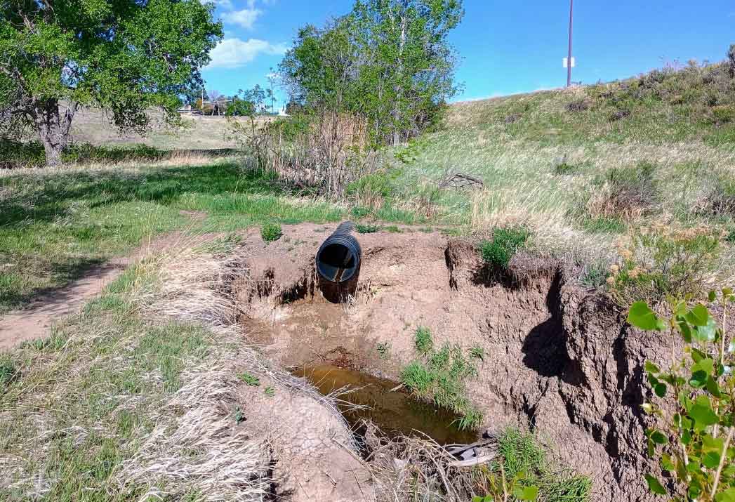 Drainage ditch and pipe (poorly maintained, if at all) down the hill from the intersection of Jewell and Wright, behind the Dunstan Middle School.